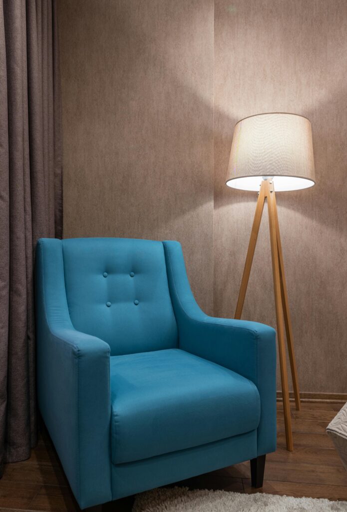 Modern interior design featuring a blue armchair and a tripod lamp.